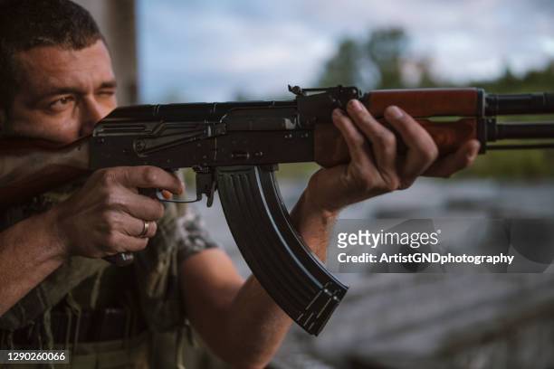 mens die met ak-47 ontspruit - kalasjnikov stockfoto's en -beelden