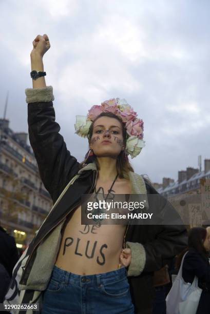 Femme brandissant le poing aux seins nus avec le slogan sur la poitrine "Pas une de plus" en soutien aux FEMEN lors de la manifestation contre les...
