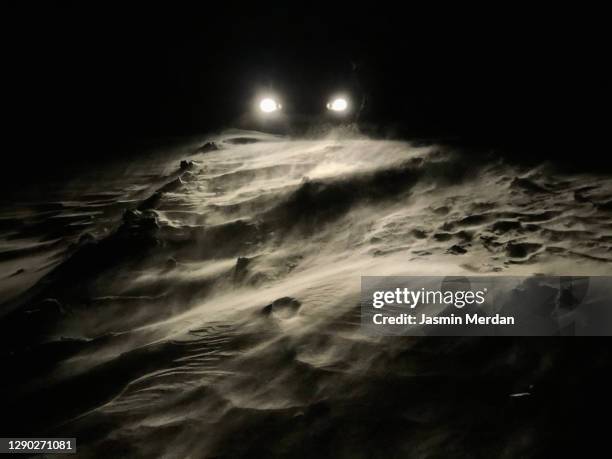 snow falls on the road in the headlights - dark country road stock pictures, royalty-free photos & images