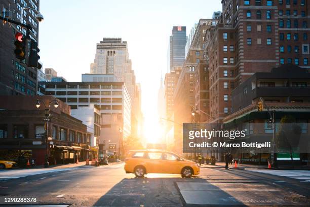 yellow cab driving on the 33st street at sunrise, new york city - yellow taxi 個照片及圖片檔