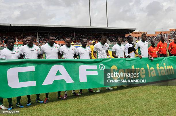 Ivorian and Burundian national team players pose on October 9, 2011 at the Felix Houphouet Boigny stadium in Abidjan with a banner, reading:...