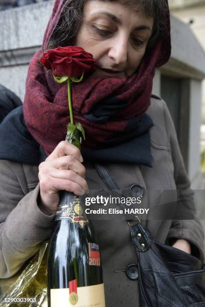 Une fan avec une rose et une bouteille de champagne en référence à la chanson de Jacques Higelin lors de son l'enterrement au cimetière du Père...