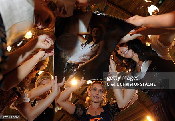 Young farmer models present a photo during the press presentation for the new "Bavarian and Austrian farmer's wifes calendar 2012" at the...