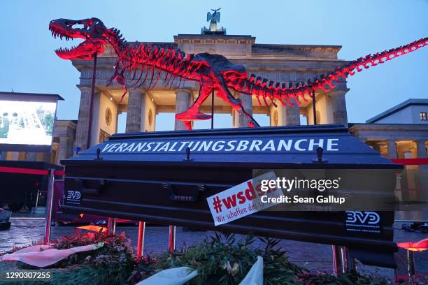 Real dinosaur skeleton, meant to to symbolize the 'dinosaur politics' of the government, stands next to a coffin with "events sector" written on it...