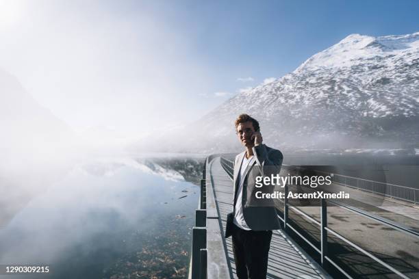 business man relaxes by wintery mountain lake in the morning - switzerland business stock pictures, royalty-free photos & images