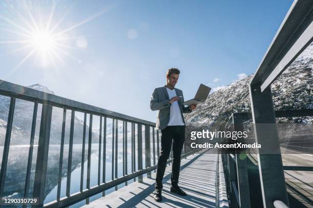 business man relaxes by wintery mountain lake in the morning - switzerland business stock pictures, royalty-free photos & images