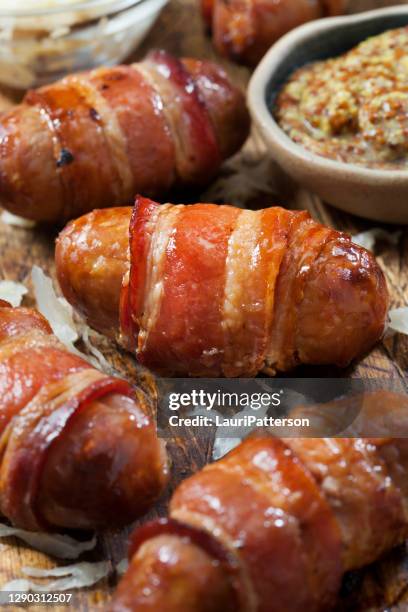mini bacon verpakte bratwurst worstjes met zuurkool en korrelige mosterd - grainy mustard stockfoto's en -beelden