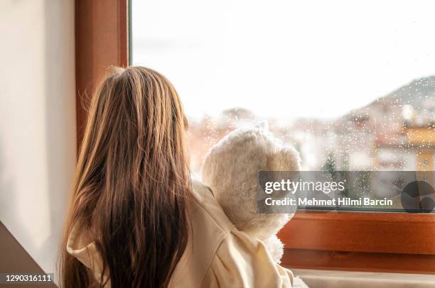 leuk meisje dat thuis met haar teddybeer boring - kindermishandeling stockfoto's en -beelden