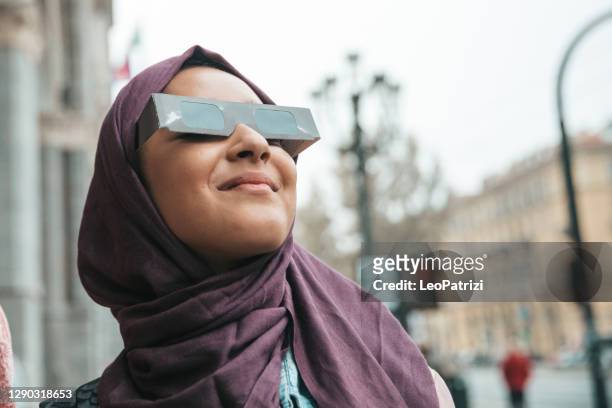 arabische vrouw die zonneverduistering bekijkt - verduistering stockfoto's en -beelden