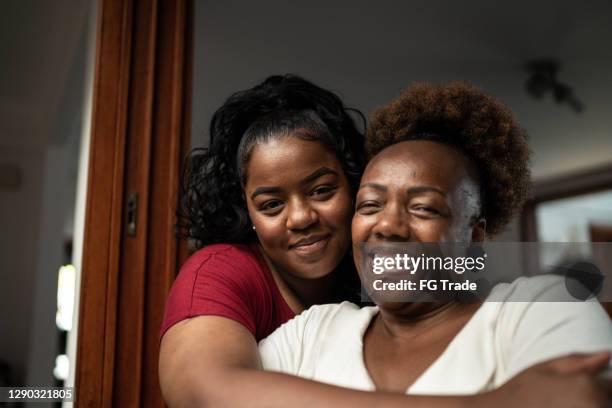 portrait of mother and daughter embracing at home - chubby granny stock pictures, royalty-free photos & images