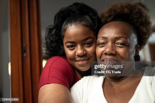 portrait of mother and daughter embracing at home - chubby granny stock pictures, royalty-free photos & images