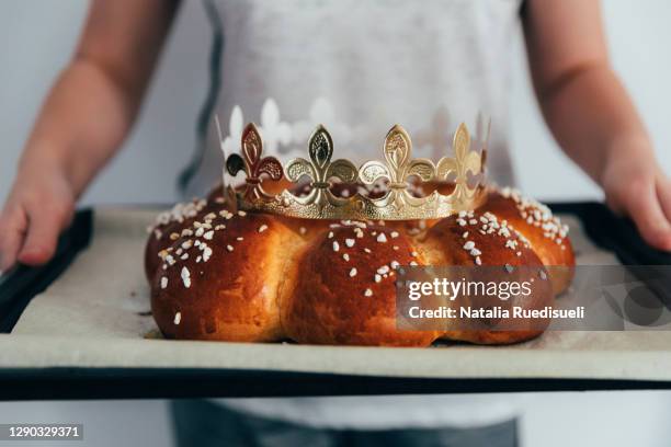 child hands holding a freshly baked homemade three king bread on baking tray. - galette photos et images de collection