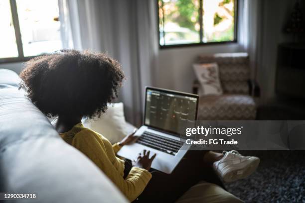 het meisje van de tiener gebruikend laptop (bestuderend of werkend) thuis - financial planner stockfoto's en -beelden
