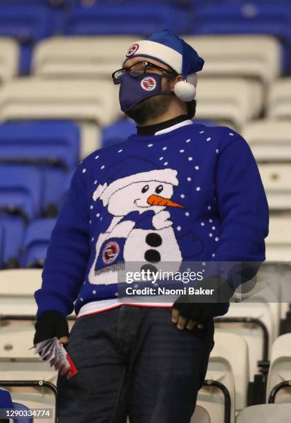 Fan wearing a face mask and a Christmas hat looks on ahead of the Sky Bet Championship match between Reading and Birmingham City at Madejski Stadium...