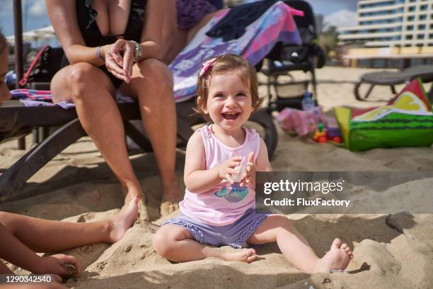 chica emocionada toodler jugando en la arena durante las vacaciones de mar con su familia - toodler fotografías e imágenes de stock