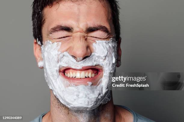 a portrait of a caucasian man smiling, with shaving foam on his face - man shaving foam stock pictures, royalty-free photos & images