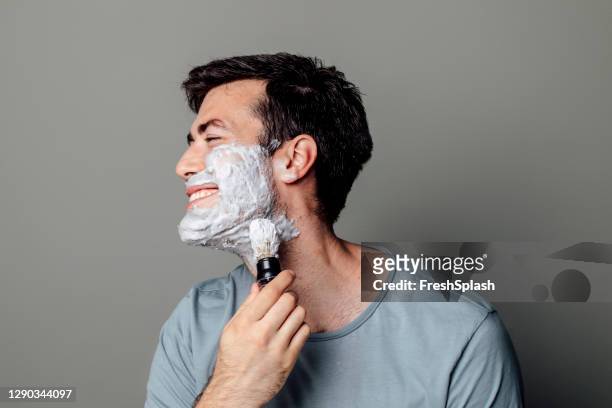 glücklich kaukasischen mann anwendung rasieren creme mit rasierpinsel - shaving brush stock-fotos und bilder