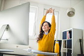 Woman stretching and working at home