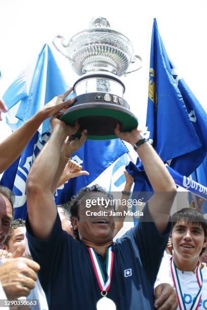 Hugo Sanchez Coach of Pumas celebrates with the trophy during the final match of Champion of Champions between Pachuca Champion of Apertura 2003 and...