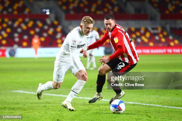 Kamil Jozwiak of Derby County runs past Henrik Dalsgaard of Brentford during the Sky Bet Championship match between Brentford and Derby County at...