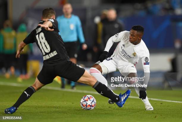 Vinicius Junior of Real Madrid turns with the ball under pressure from Stefan Lainer of Borussia Moenchengladbach during the UEFA Champions League...