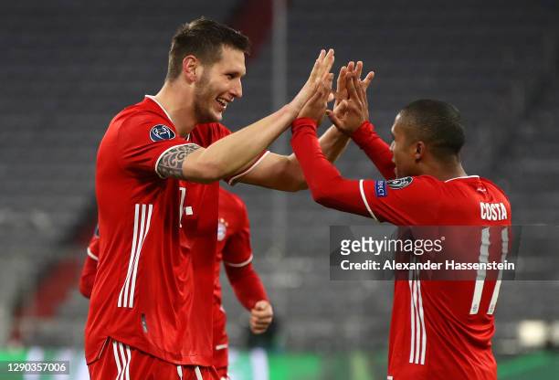 Niklas Suele of FC Bayern Munich celebrates with team mate Douglas Costa after scoring their sides first goal during the UEFA Champions League Group...