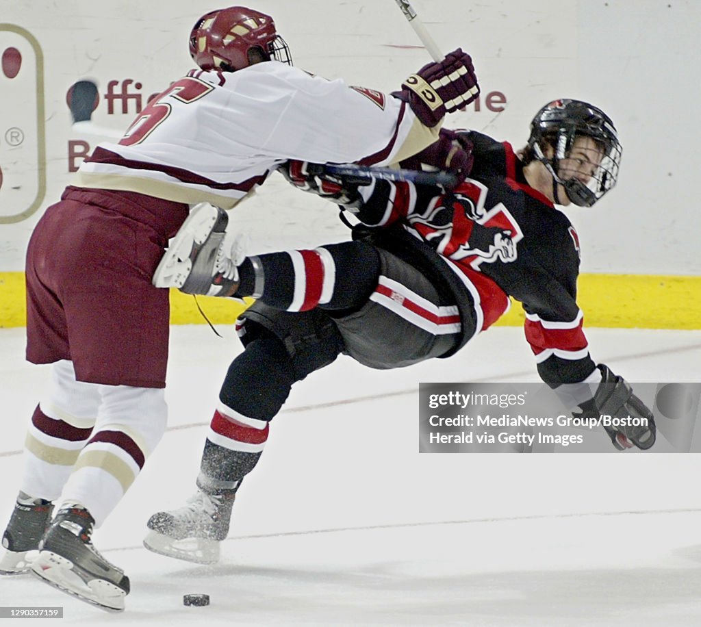 1/6/06 - NEWTON, MA - Boston College Men's Ice Hockey v Northeastern at BC's Kelley Rink Friday. BC's Tim Kunes, left, delivers a hard hit to Northeastern's Joe Santilli, right, during first period action. (010606bcicedg- Staff Photo by David Gol