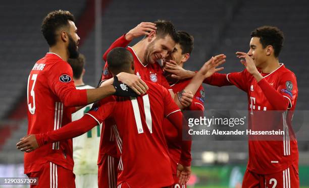 Niklas Suele of FC Bayern Munich celebrates with team mates Douglas Costa, Eric Maxim Choupo-Moting, Marc Roca and Jamal Musiala after scoring their...