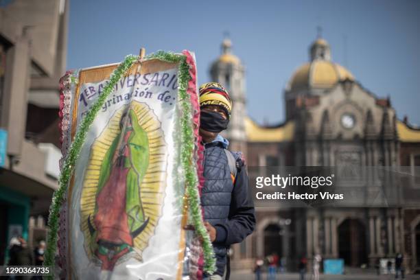 Pilgrim carrying a banner with the image of the Virgin of Guadalupe stands out the ahead of the Day Of Our Lady Of Guadalupe celebrations at Basilica...