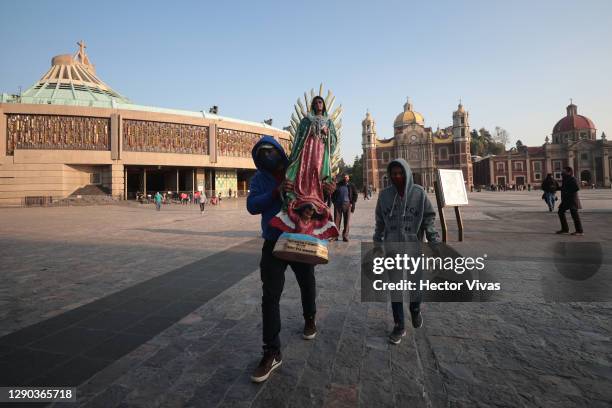 Person carrying a statue of the Virgin of Guadalupe leaves the Basilica ahead of the Day Of Our Lady Of Guadalupe celebrations at Basilica de...