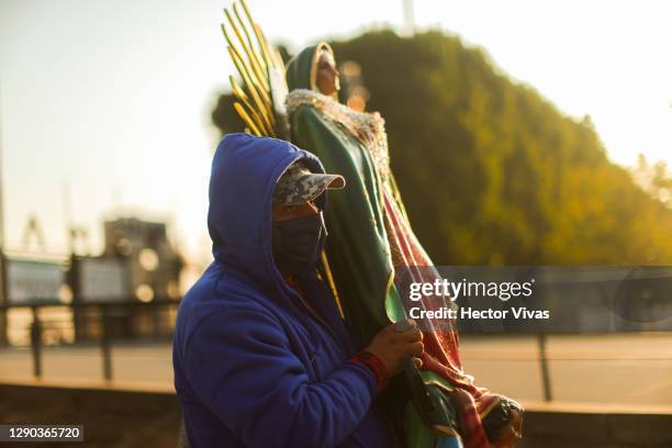 Person carrying a statue of the Virgin of Guadalupe leaves the Basilica ahead of the Day Of Our Lady Of Guadalupe celebrations at Basilica de...
