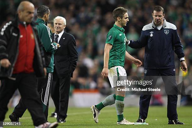 Kevin Doyle of Republic of Ireland walks off the pitch after being sent off aided by Alan Kelly the Ireland goalkeepoing coach as Giovanni Trapattoni...