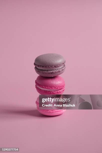 stack of delicious french desserts cookies macarons over pink background - macaron photos et images de collection