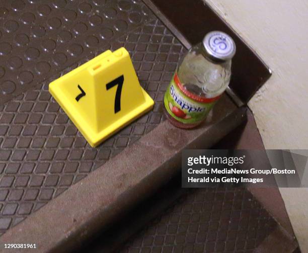 An evidence marker left by Boston Police marks a bottle of Snapple in the stairwell of deceased man who was allegedly shot while trying to rob an...