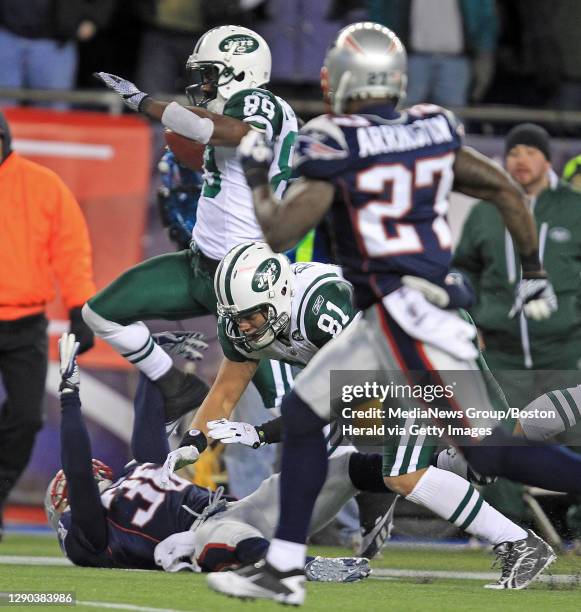 New York Jets wide receiver Jerricho Cotchery runs in for a touchdown as he runs over New England Patriots safety Josh Barrett in the second half of...
