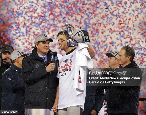 New England Patriots quarterback Tom Brady holds up the trophy as New England Patriots head coach Bill Belichick applauds after beating the Colts...
