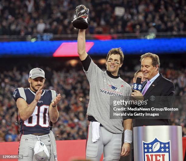 New England Patriots wide receiver Danny Amendola applauds as quarterback Tom Brady holds up the AFC Championship trophy after beating the...