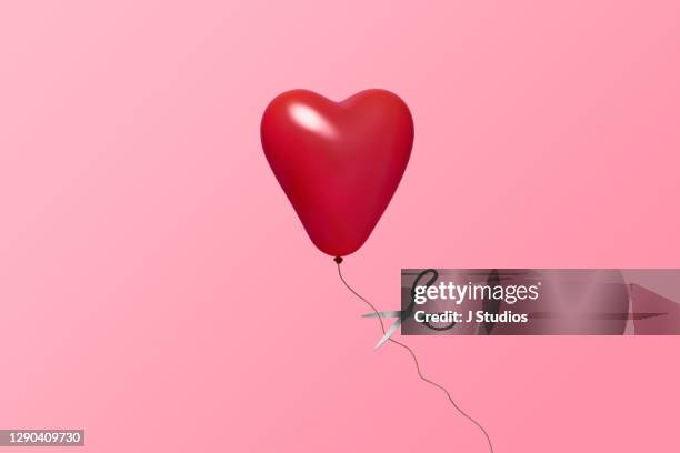 heart balloon about to be let go - frustration stockfoto's en -beelden