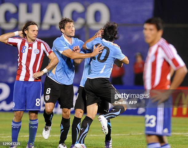 Uruguayan player Diego Forlan is congratulated by teammates Alvaro Gonzalez and Sebastian Eguren after he scored against Paraguay, during a Brazil...