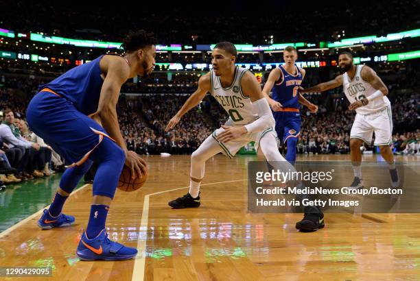 New York Knicks guard Courtney Lee, left, is guarded by Boston Celtics' Jayson Tatum as New York Knicks' Kristaps Porzingis moves into position past...