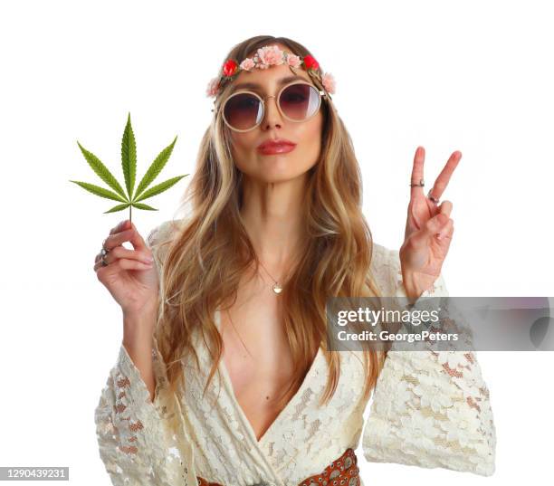 volwassen hippievrouw die cannabisblad houdt - hippie stockfoto's en -beelden