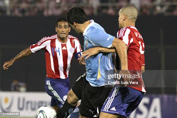 Sebastian Eguren of Uruguay, fights for the ball with Dario Veron and Paulo Da Silva of Paraguay, during the match between Paraguay and Uruguay as...