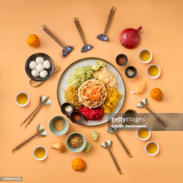 chinese new year food and drinks, raw fish salad “yusheng” on cream coloured background flat lay image. - still life foto e immagini stock