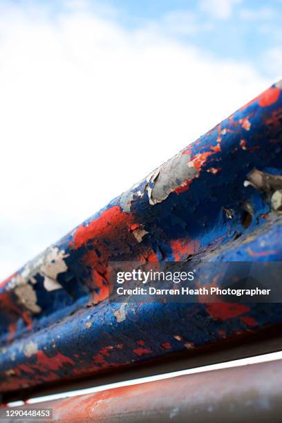 Red, white and blue peeling paint on race track edging Armco crash barriers at the 2010 British Grand Prix, Silverstone Circuit, England, United...