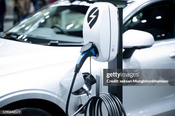 electric car in charging - alternative fuel vehicle stock-fotos und bilder