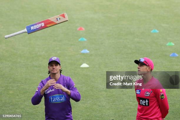 Captains Peter Handscomb of the Hurricanes and Daniel Hughes of the Sixers take part in the bat flip during the Big Bash League match between the...
