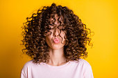 Headshot of girl with curly hairstyle wearing t-shirt send air kiss pouted lips isolated on vivid yellow color background