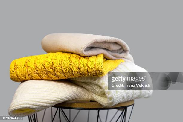 stack of trendy bright illuminating yellow, gray and white woolen knitted sweaters. - clothing photos et images de collection
