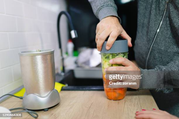 male hands closing blender jar with ingredients for healthy smoothie - blended drink stock pictures, royalty-free photos & images