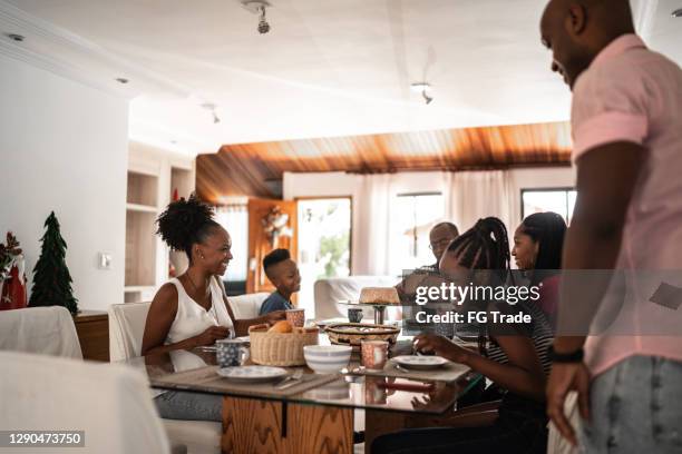 mehrgenerationenfamilie beim gemeinsamen frühstück zu hause - familie zuhause essen stock-fotos und bilder